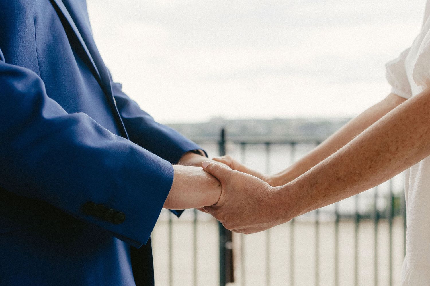 A close-up shot of hands joining together during a wedding ceremony.