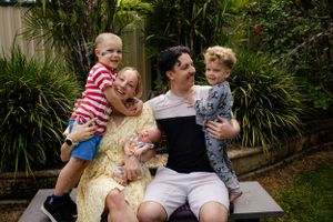 A family shares a joyful moment together outdoors in a garden setting.