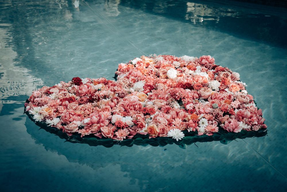 A romantic heartshape made of floating rose petals in the water during a luxury surprise proposal in Mallorca.