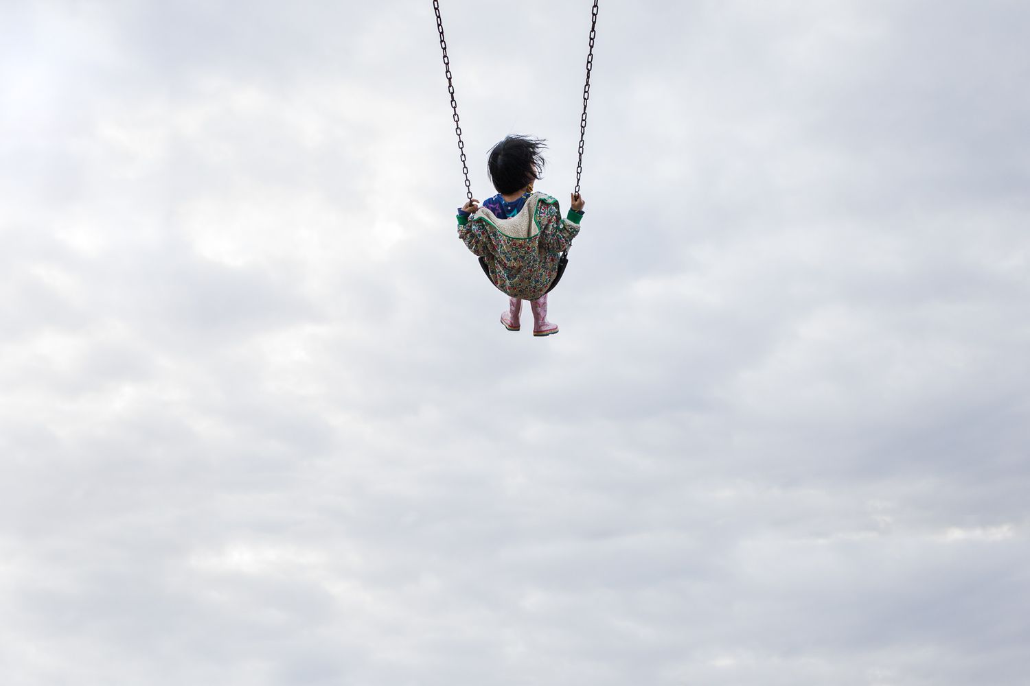 My daughter riding a swing at the park