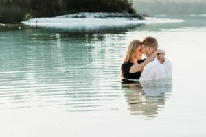 Intimate couple portrait in serene turquoise waters during golden hour.
