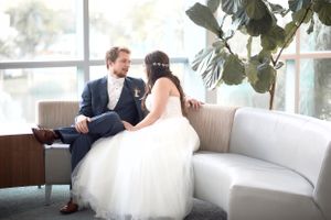 Photo of bride and groom talking on a sofa during the wedding by Anguelo Photography