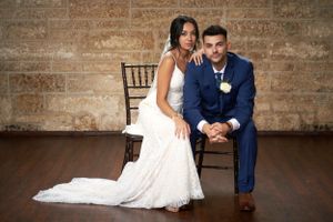 Portrait of a bride and groom sitting in chairs by Anguelo Photography