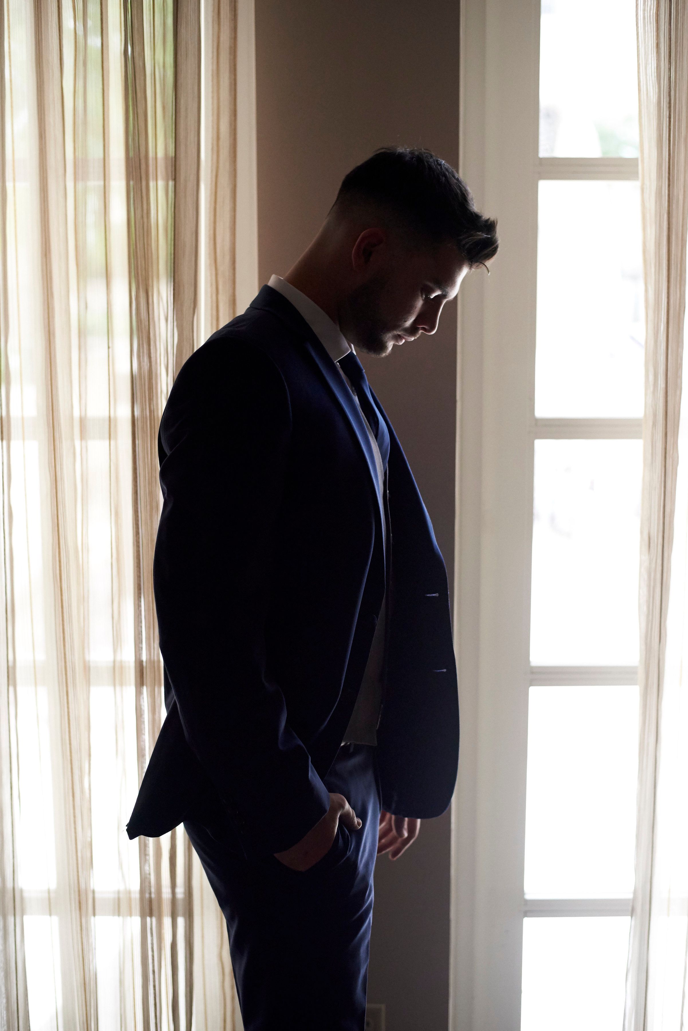Photo of a silhouette of a groom before the wedding by Anguelo Photography