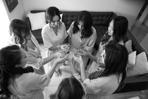 Black and white photo of bridesmaids toasting before the wedding by Anguelo Photography