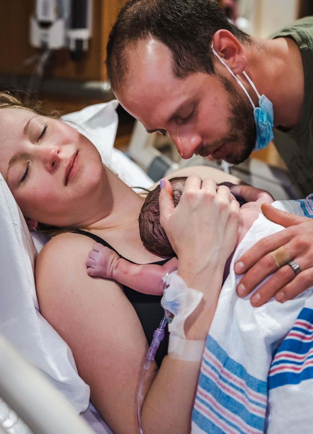 An intimate moment as parents meet their newborn baby for the first time in the delivery room.