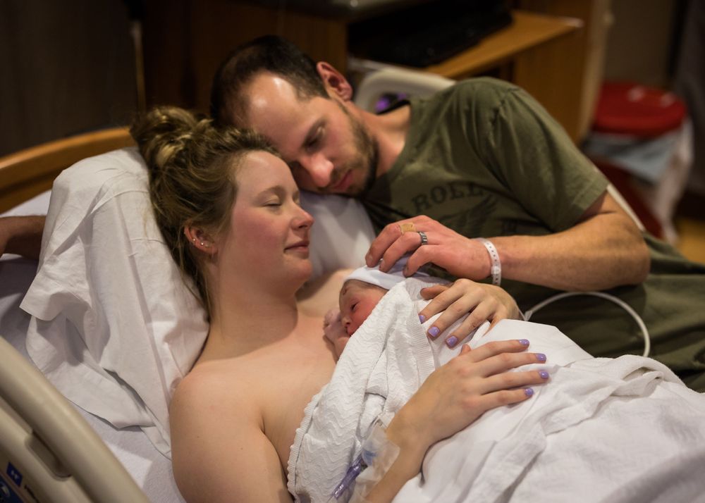A tender moment in a hospital room as new parents bond with their newborn.