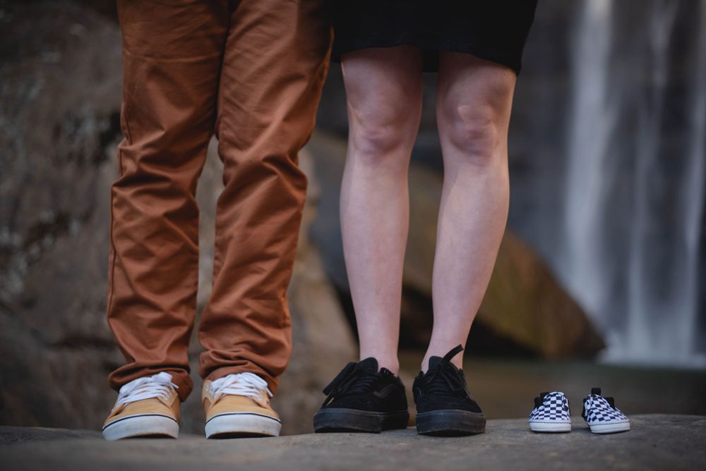 Maternity portrait session of mother and father wearing Vans with a pair of baby Vans