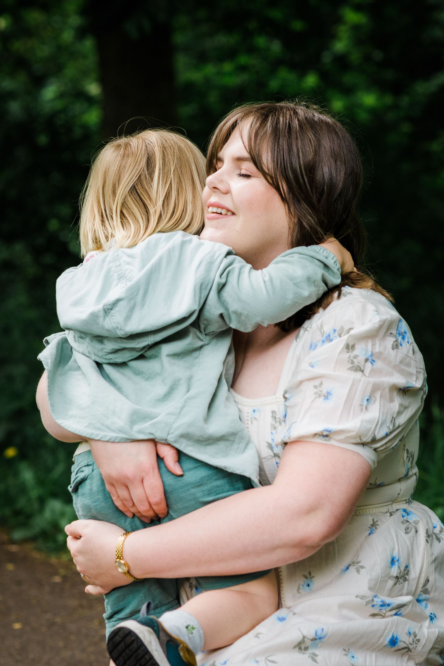 Mother with eyes closed embracing her young son