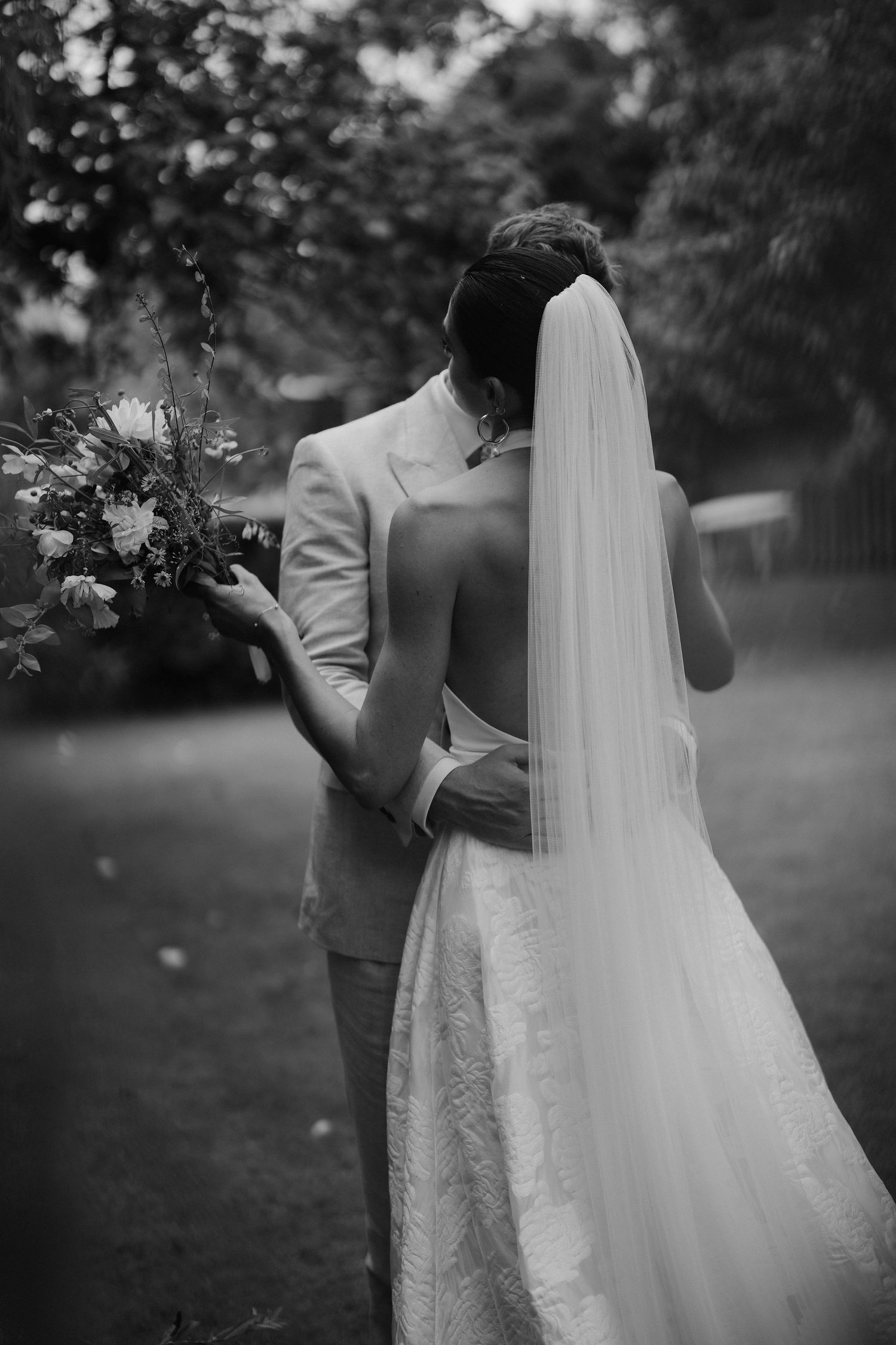 bride and groom hugging under willow tree in islip, oxfordshire