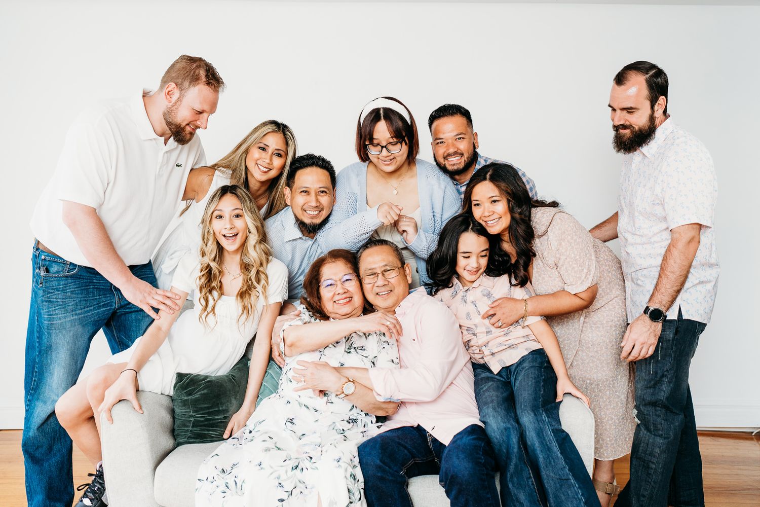Large family group poses together in white studio wearing coordinated casual outfits in the Hudson Valley,NY.