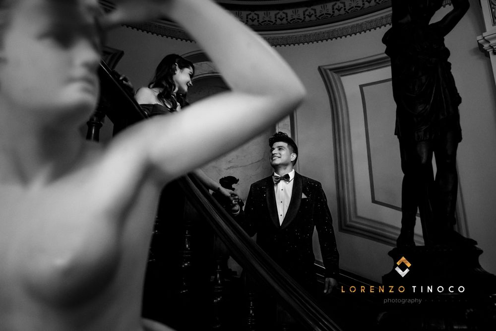 An artistic black and white photo captures movement in an ornate ballroom setting.