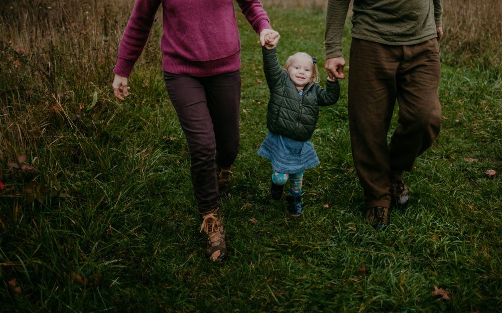 parents holding childs hands while walking portland oregon family photographer