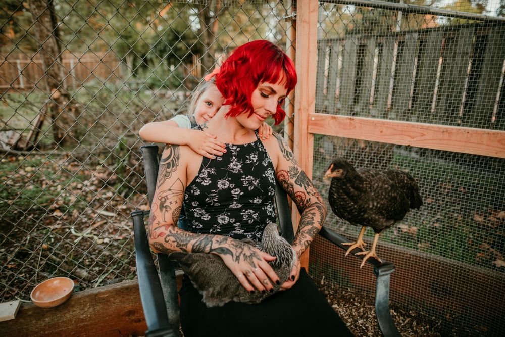 child hugs parent from behind in chicken coop portland oregon family photographer