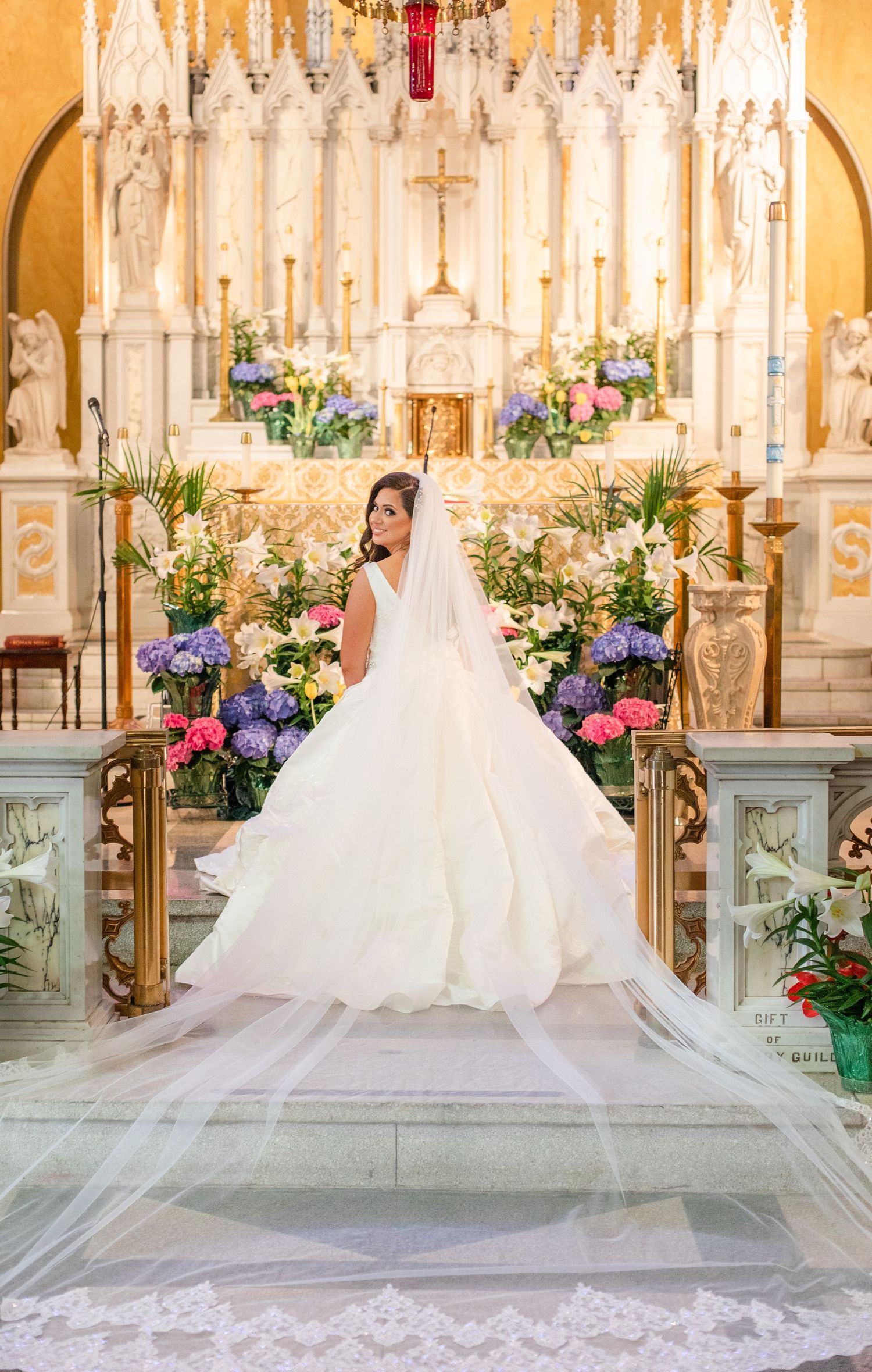 Cathedral wedding scene with dramatic lighting, floral arrangements, and a flowing white dress train.