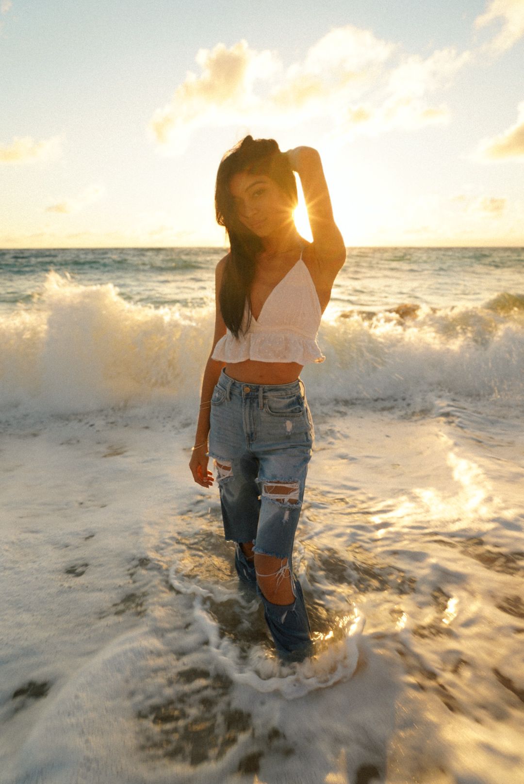 girl standing in the ocean walking the beach during a early morning at Donkeys beach Kauai