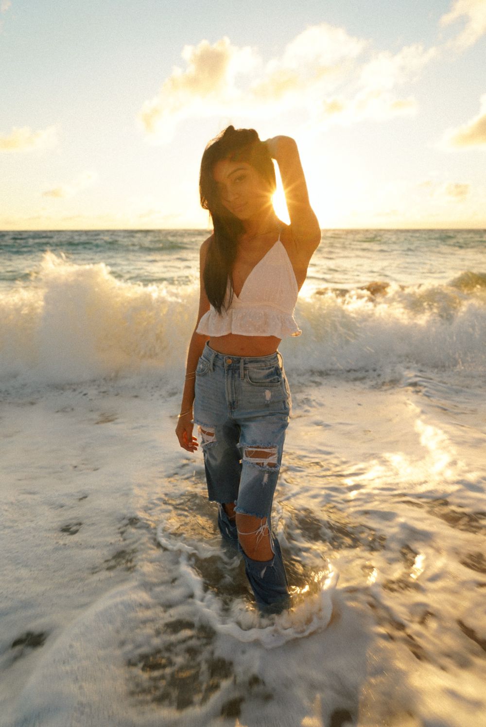 girl standing in the ocean walking the beach during a early morning at Donkeys beach Kauai