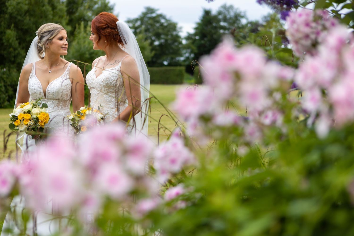 Garden wedding setting with pink flowers blooming in the foreground.