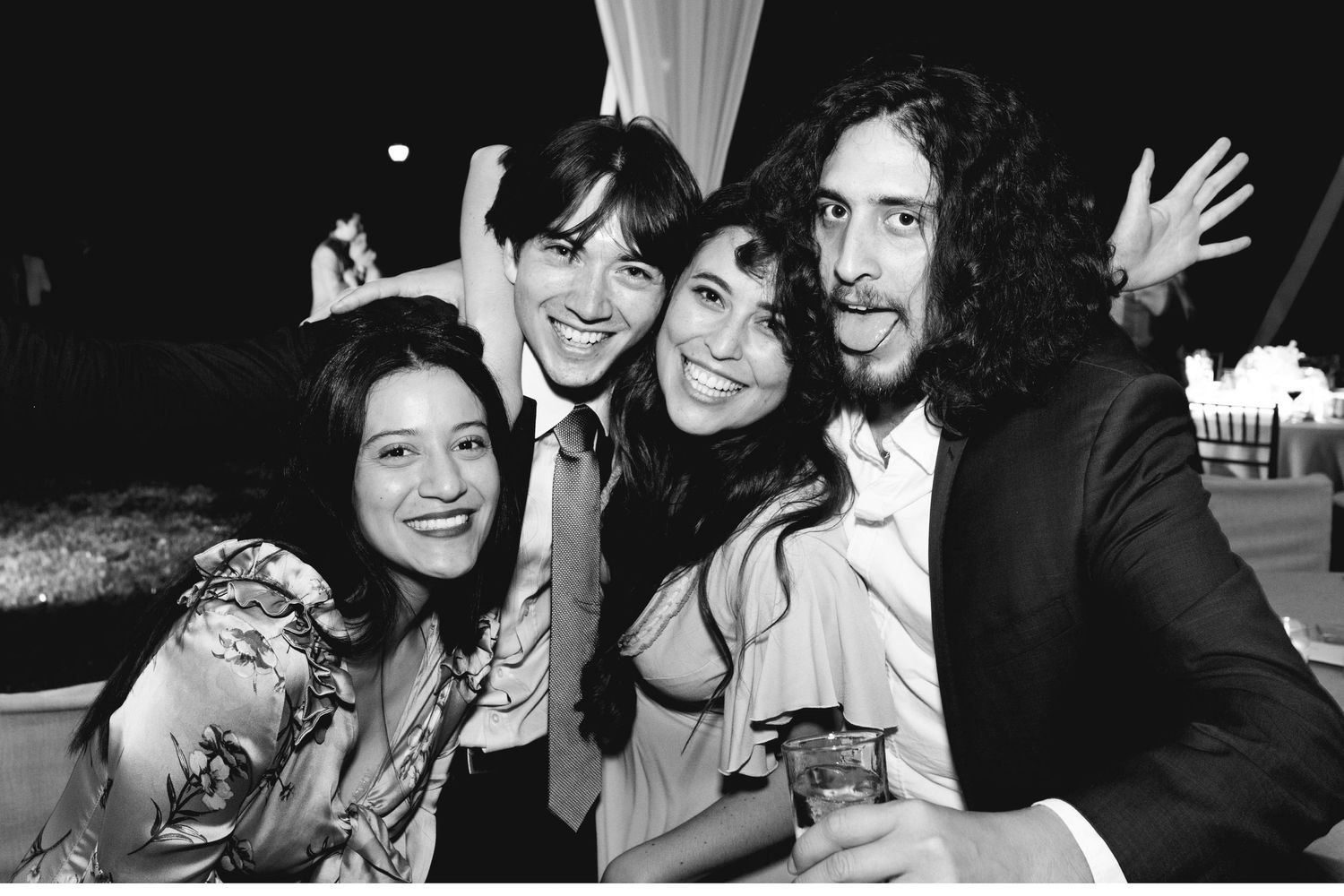 Black and white photo of friends posing together at a nighttime celebration.