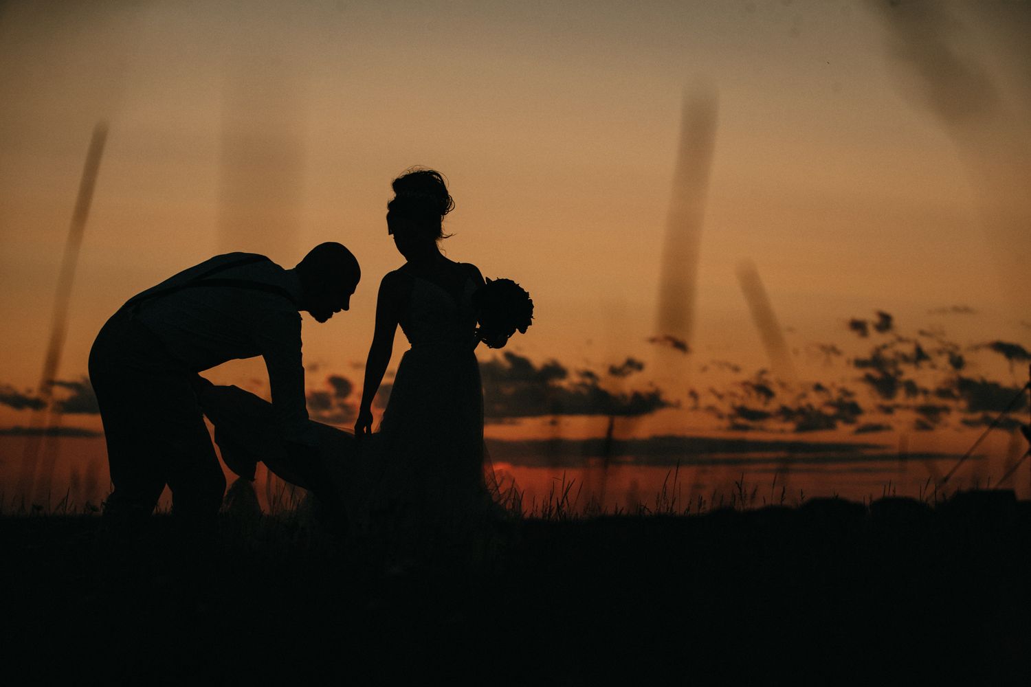 Silhouettes against sunset sky in romantic outdoor scene.