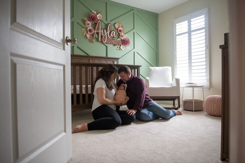 Interior view of a mint green nursery with natural light streaming through windows.