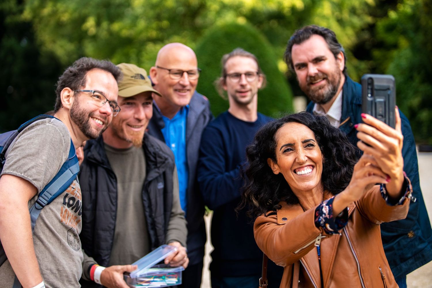 Group taking a selfie together at an outdoor event.