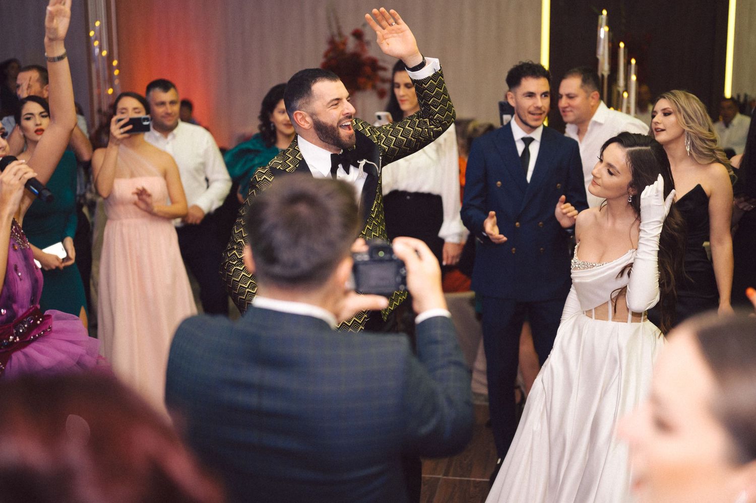 Wedding party guests dancing and celebrating on a decorated dance floor at a reception.