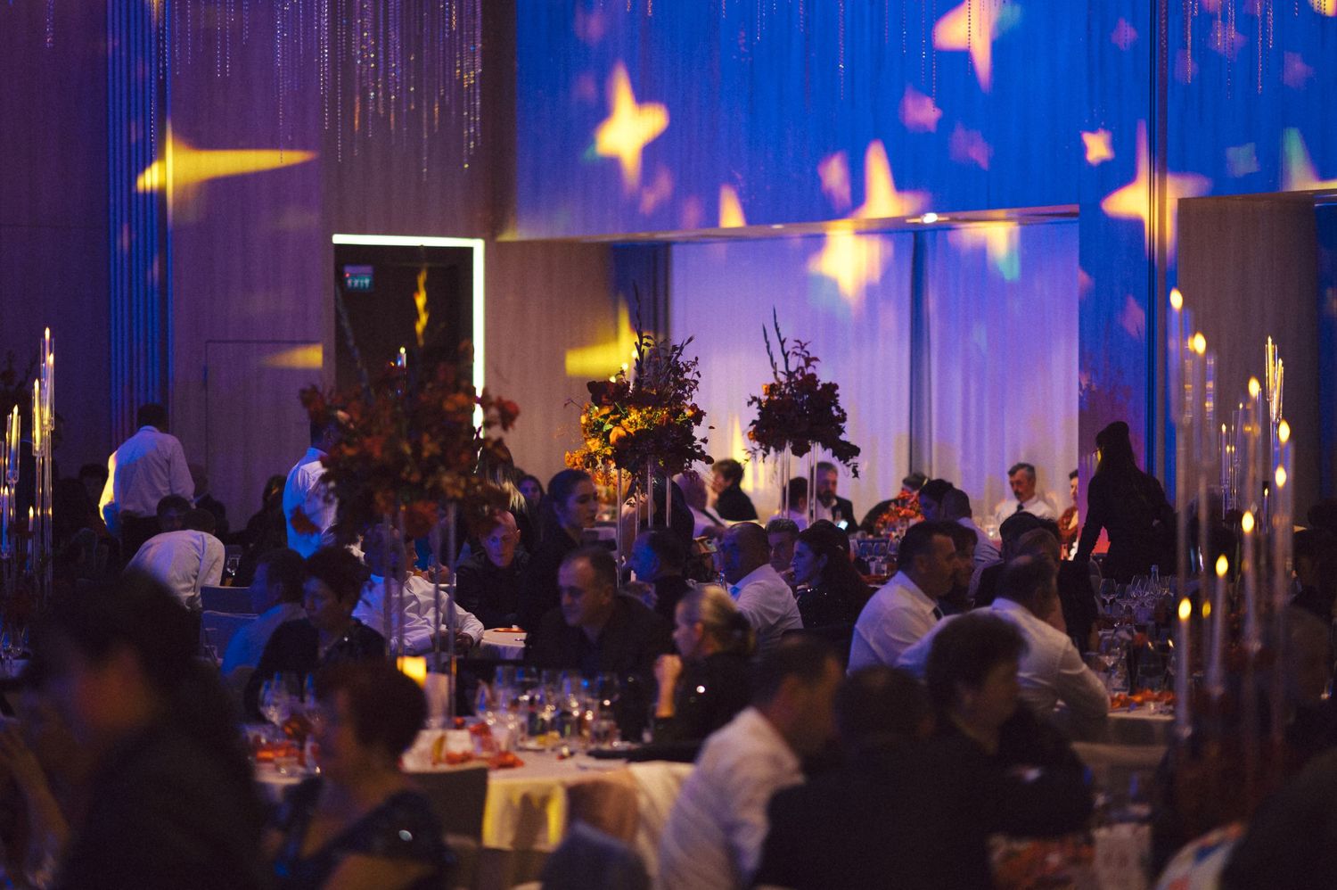 Elegant wedding reception venue with blue lighting and decorative star projections.