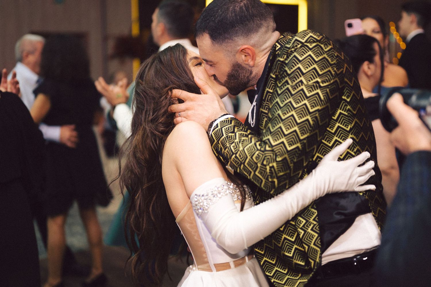 A romantic moment shared between a couple in formal attire at a wedding reception.