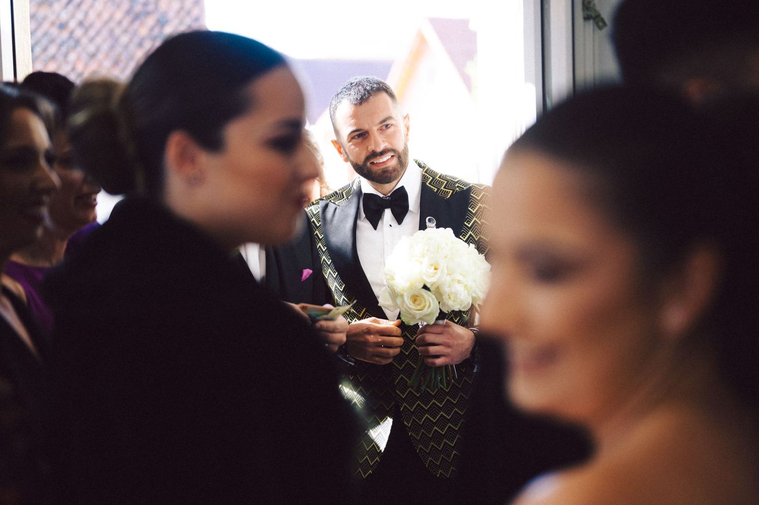 Wedding celebration candid moment with bouquet of white flowers.