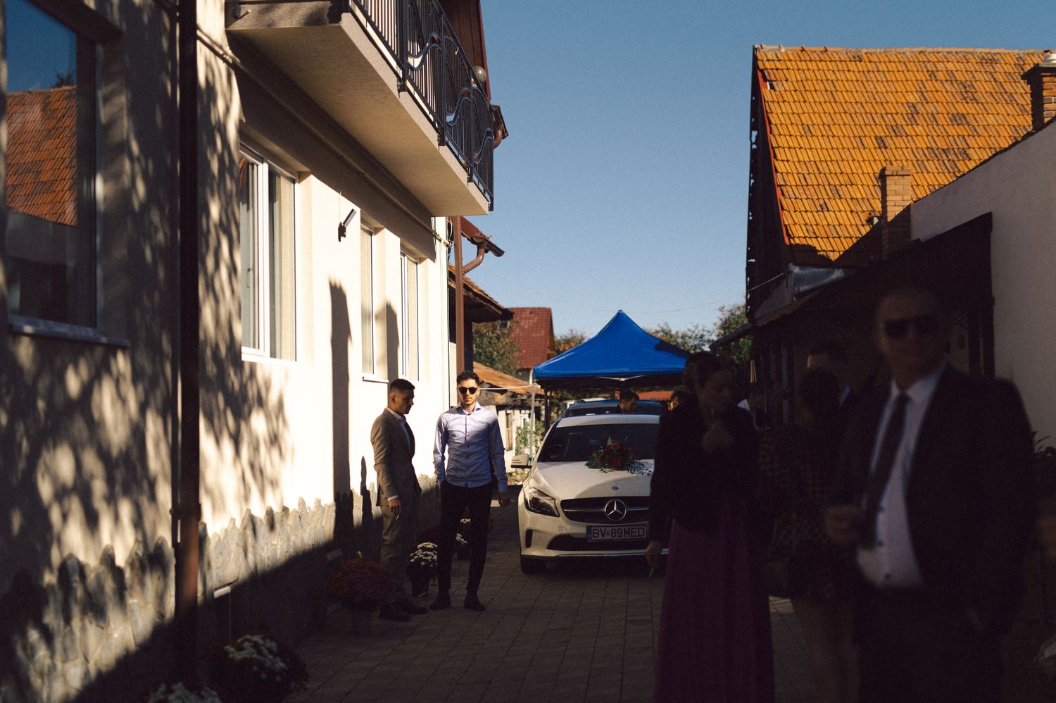 A street scene with buildings and a blue tent on a sunny day.