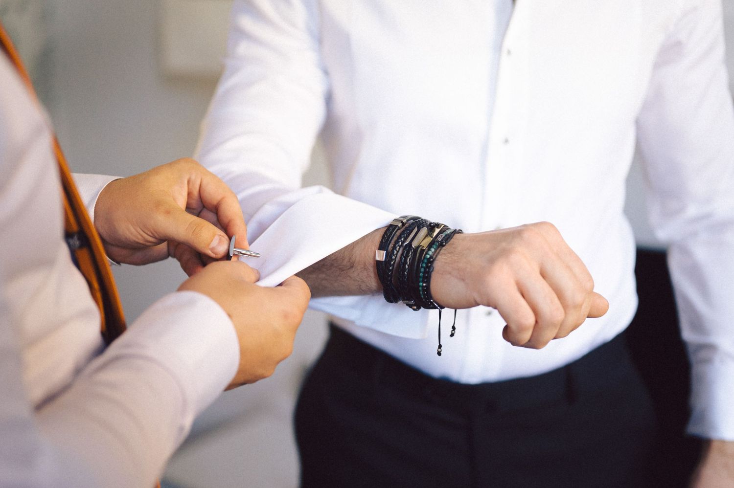 Close-up shot of someone checking their watch while getting ready for a formal occasion.