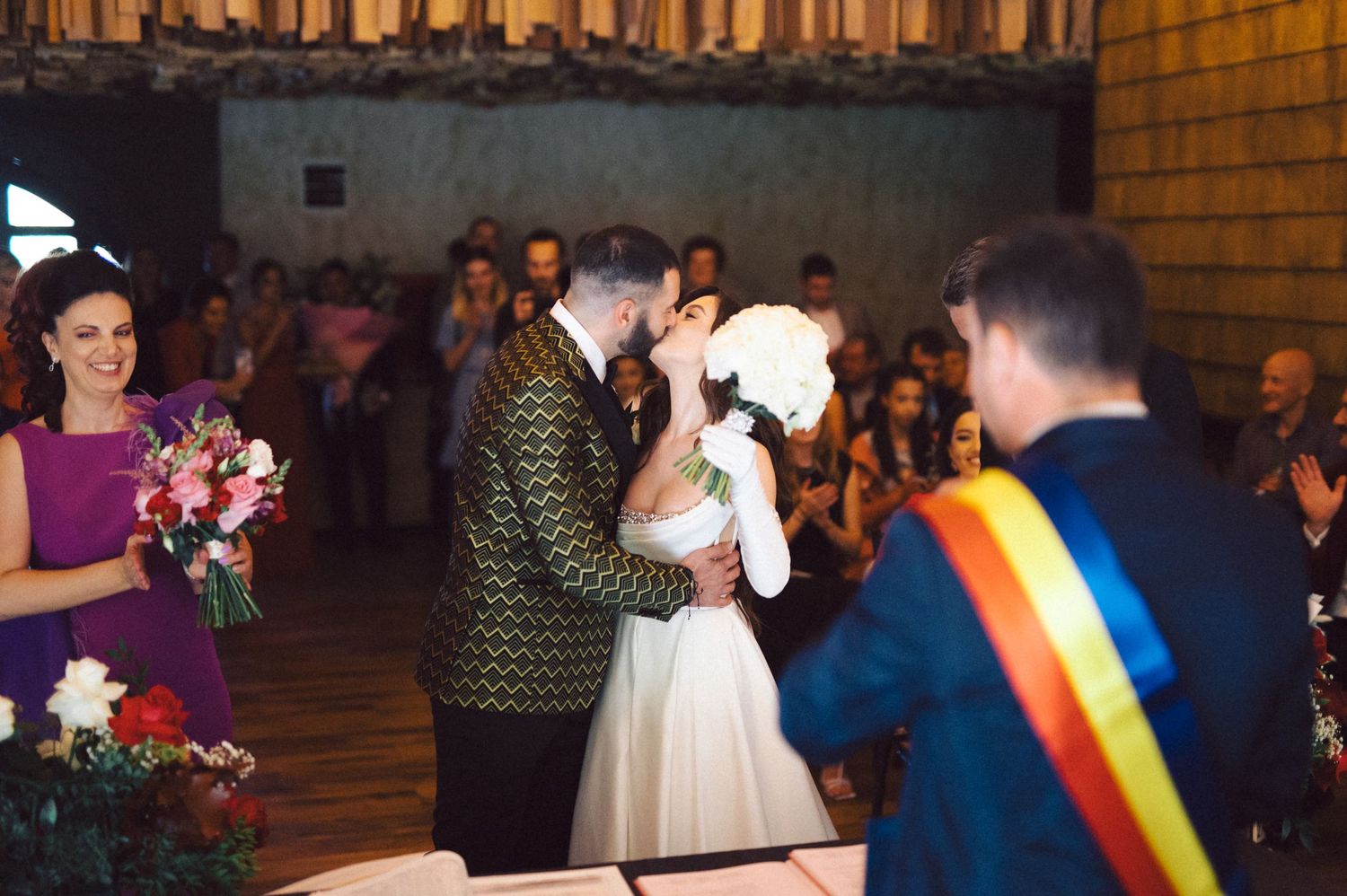 A wedding ceremony with festive decorations and colorful sashes.