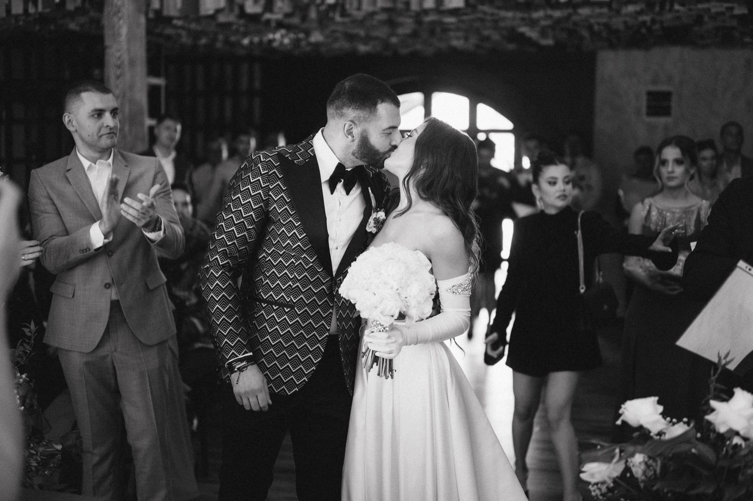 Black and white photo of a romantic moment during a wedding celebration.