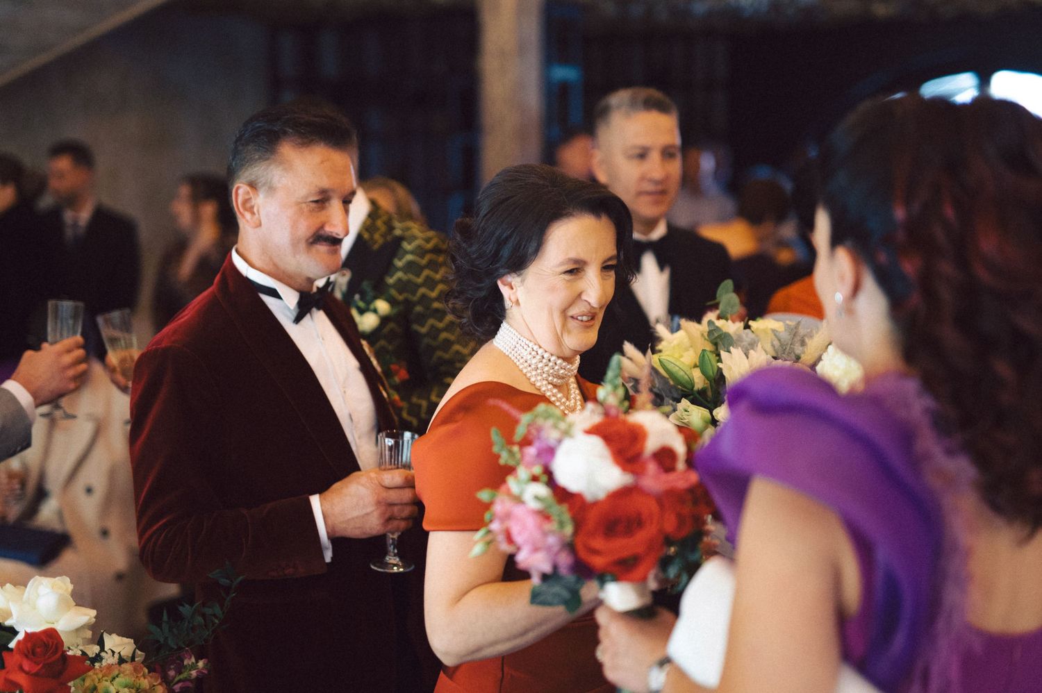 Wedding guests enjoying conversation and flowers at an elegant reception.