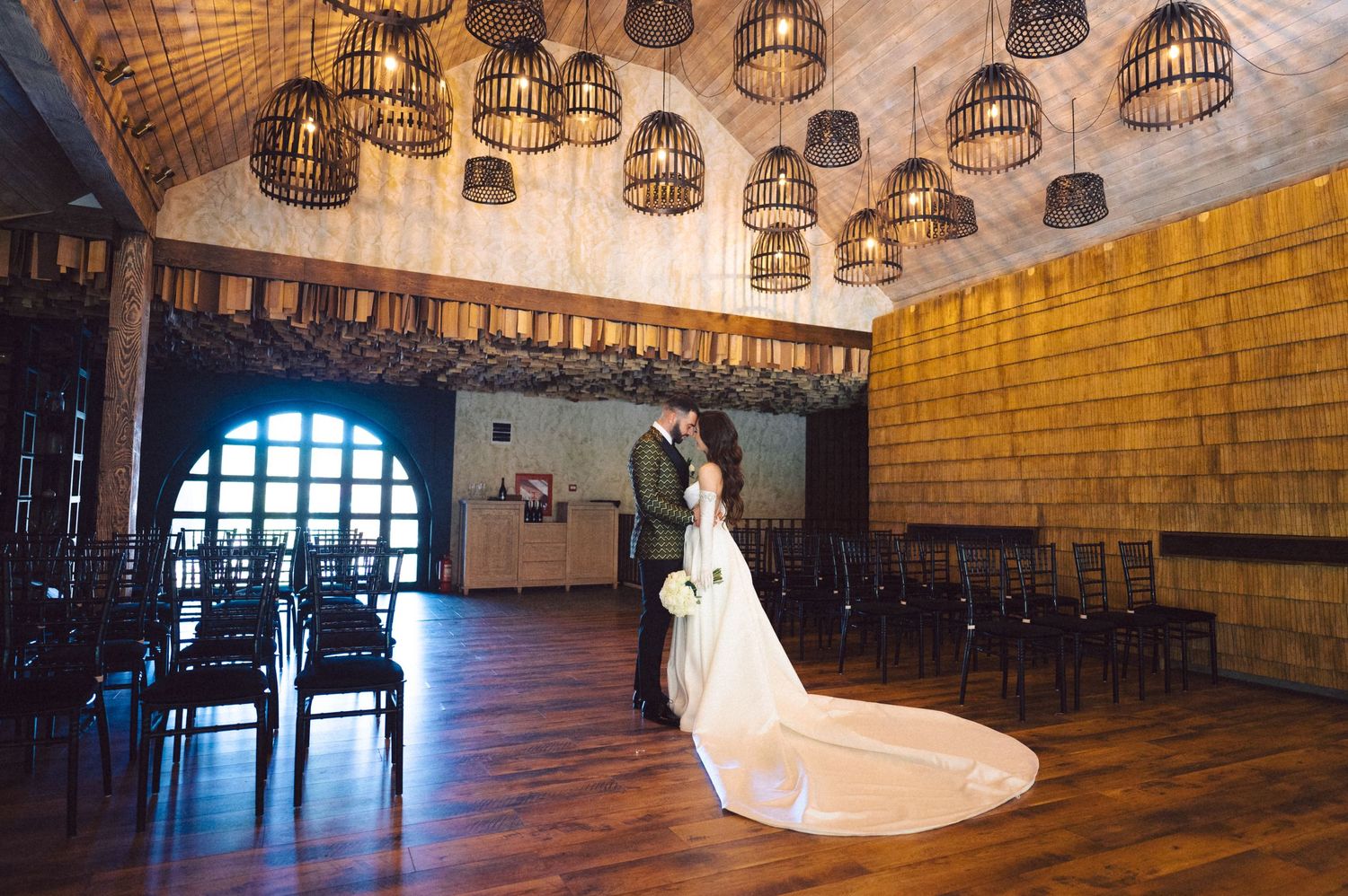Elegant ballroom with birdcage chandeliers and stone walls for romantic first dance at wedding.