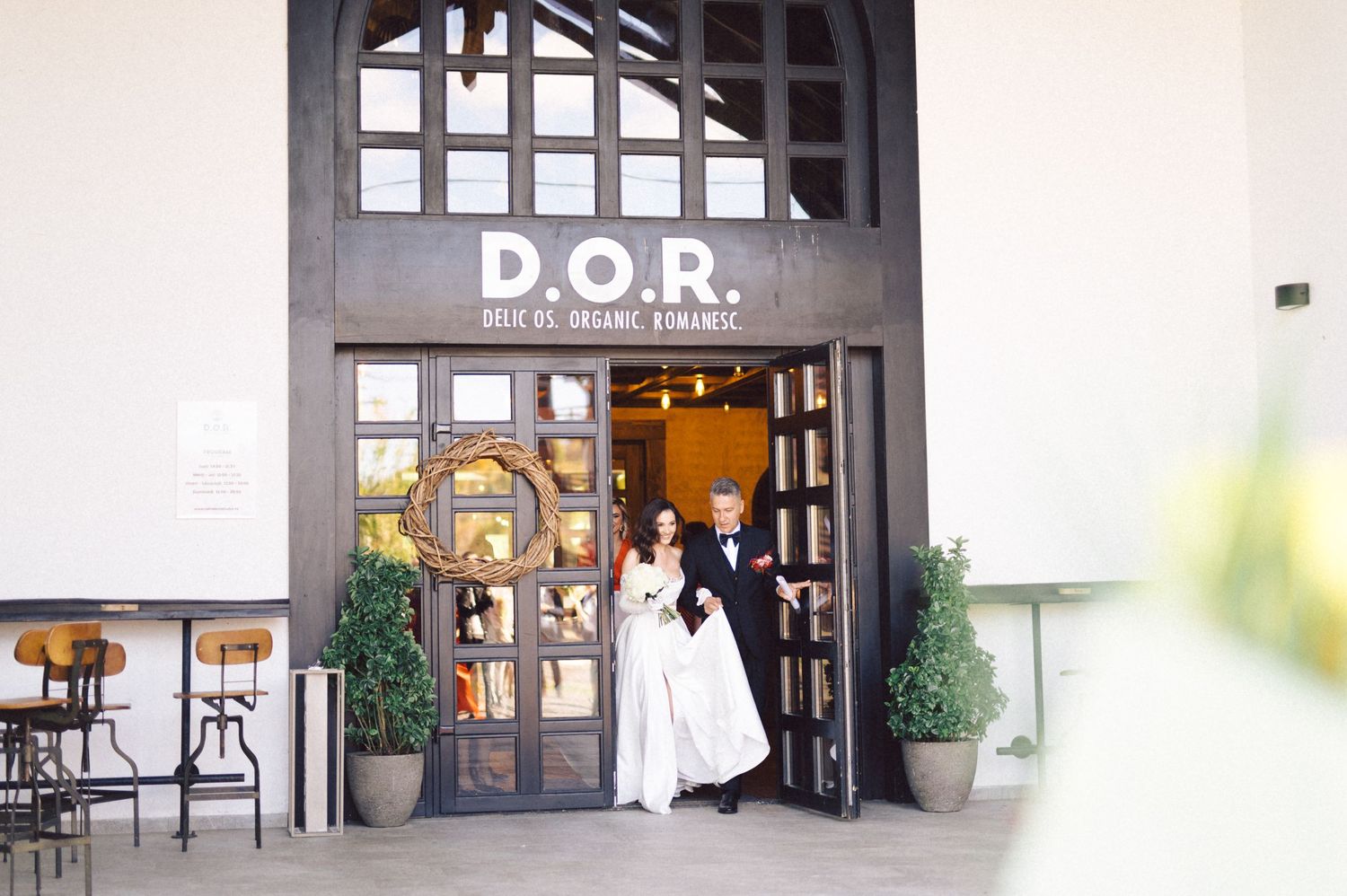 Couple entering D.O.R. venue with bride in flowing white dress.