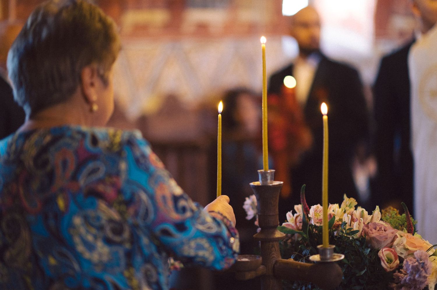 Candlelit table setting with taper candles and floral arrangements at evening reception.