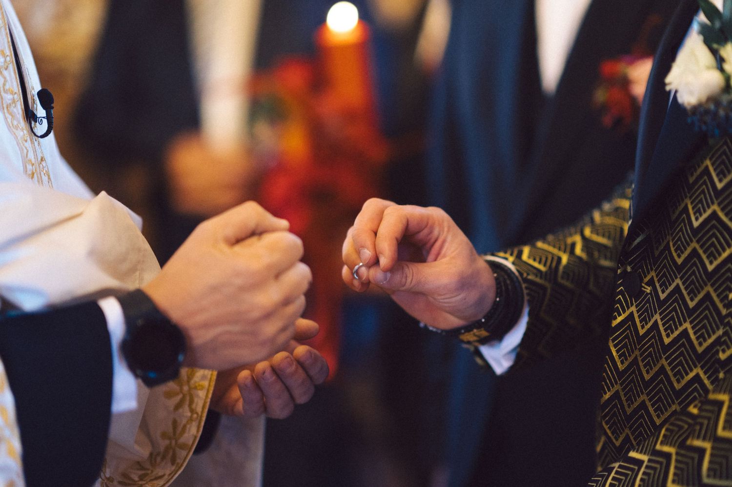 Close-up of hands exchanging rings during a wedding ceremony.