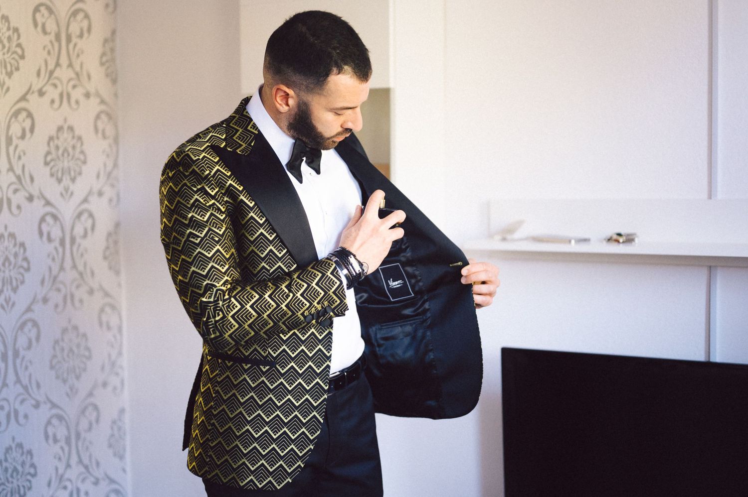 A formal tuxedo featuring a metallic gold geometric pattern jacket and white dress shirt.