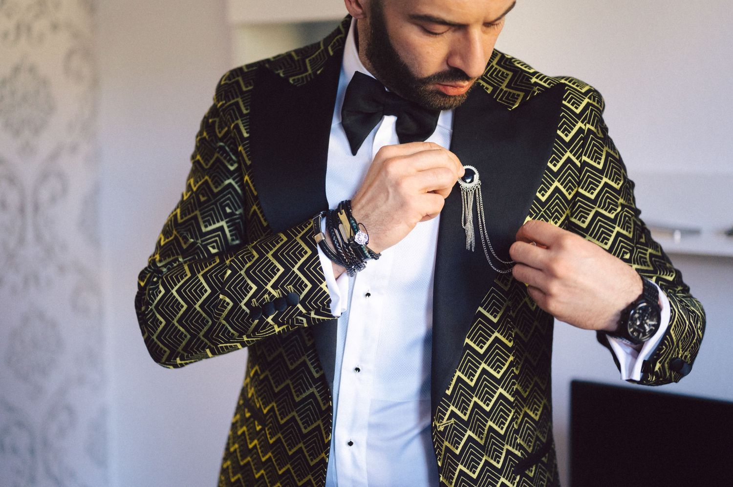 A close-up of a tuxedo with a distinctive gold geometric patterned jacket and black bow tie.