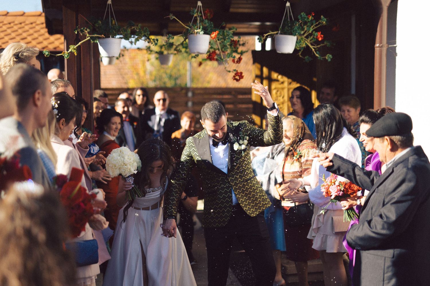 Wedding celebration unfolds with guests gathered under a decorated outdoor pavilion.