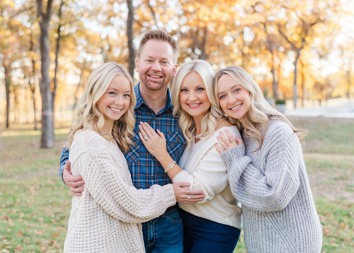 A family group shares joyful moments together outdoors during sunset in fall.