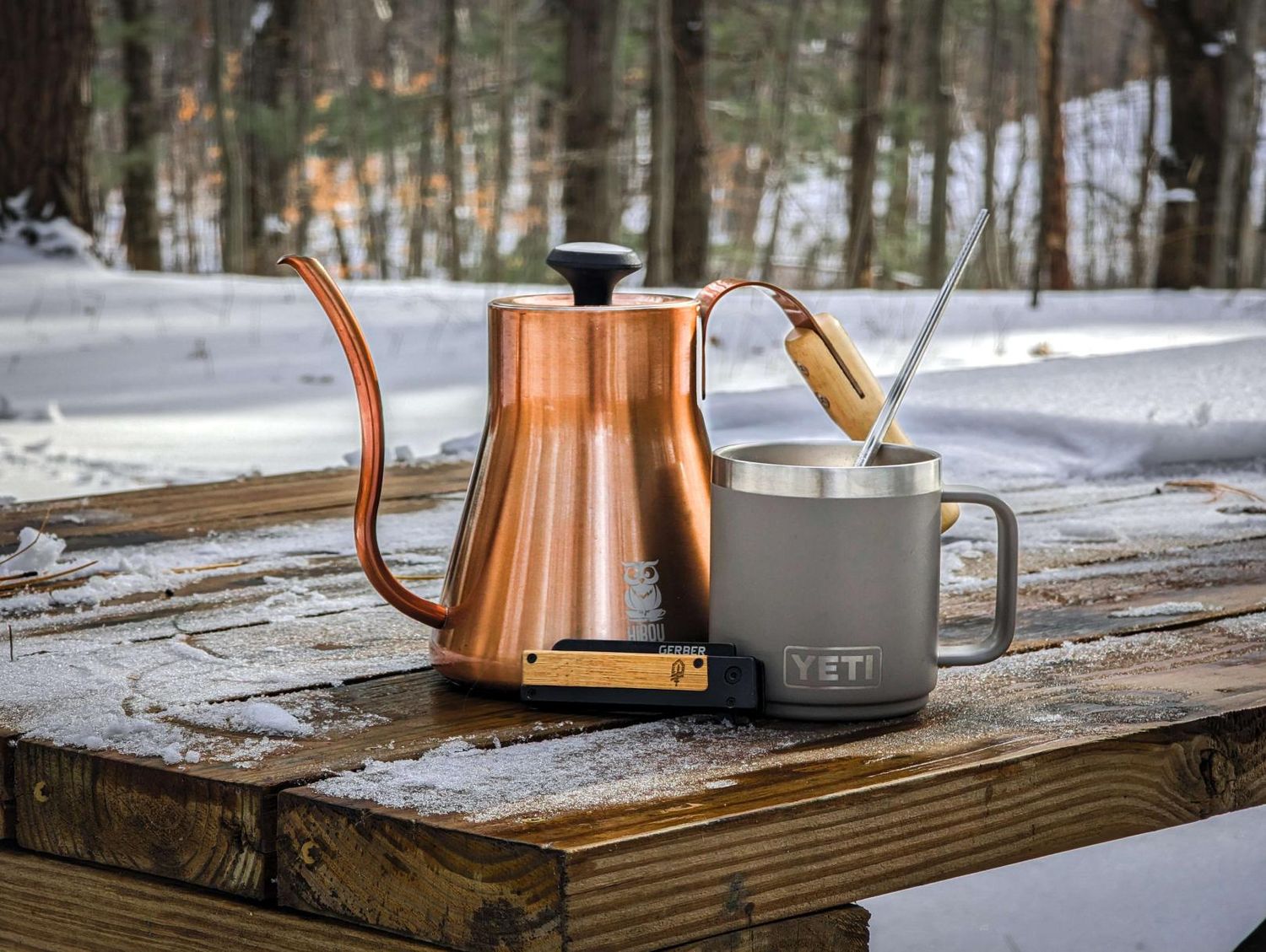 a kettle and coffee cup sit on a table next to each other