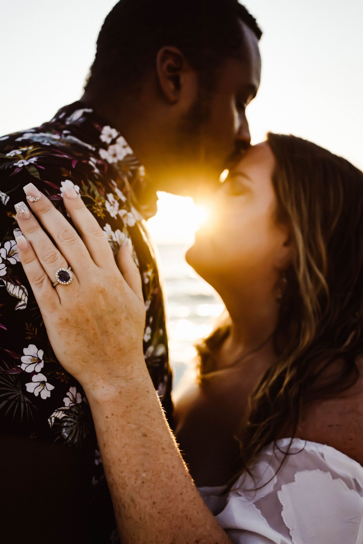 Intimate silhouettes of a couple sharing a tender moment against a golden sunset backdrop.