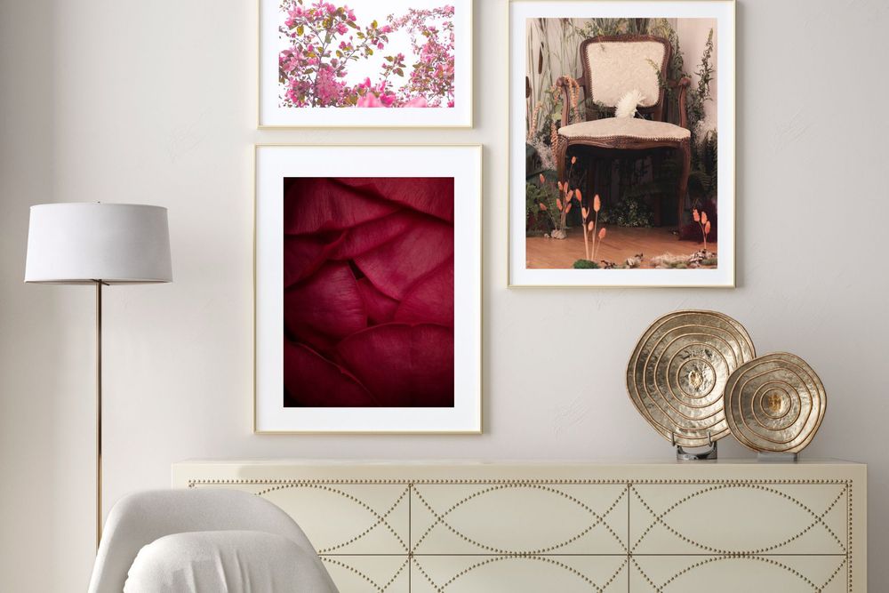 Contemporary living room wall arrangement with framed floral and abstract art prints above a white console.