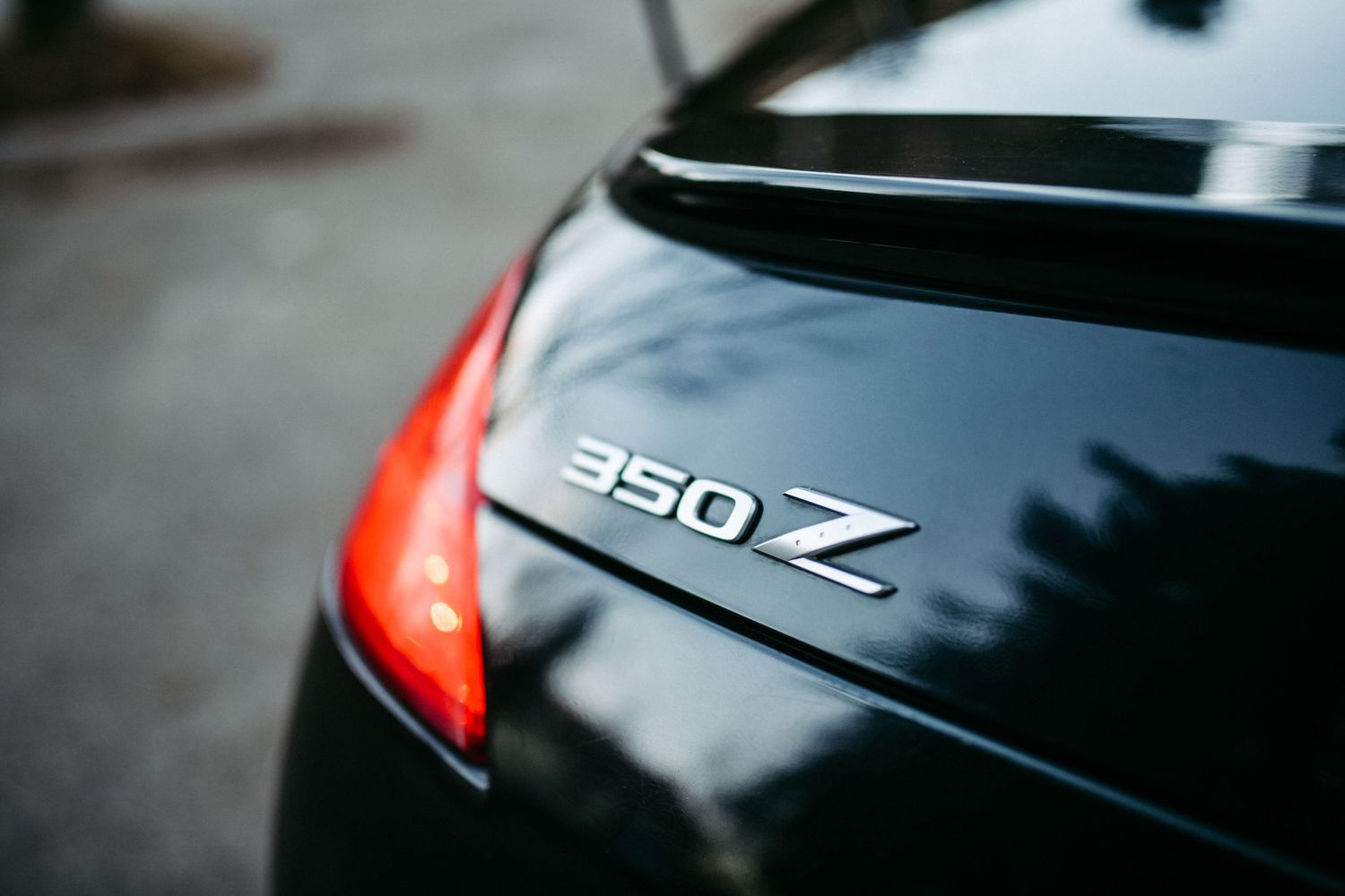 Close-up of 350Z emblem on black car trunk.