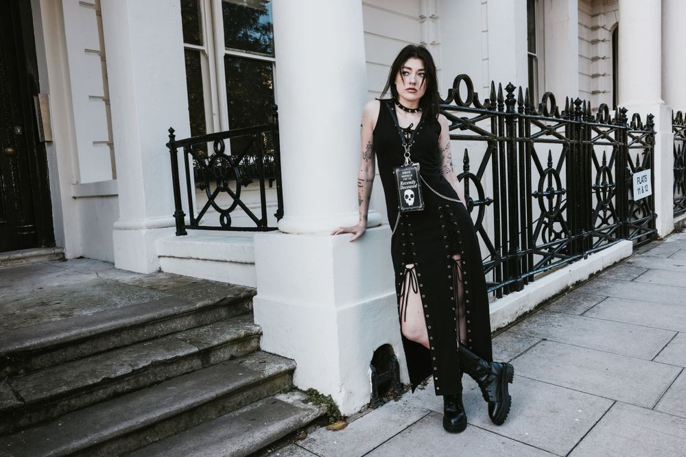 Gothic styled alternative model with dark hair posing outside a white & black building in Hove for a small fashion brand