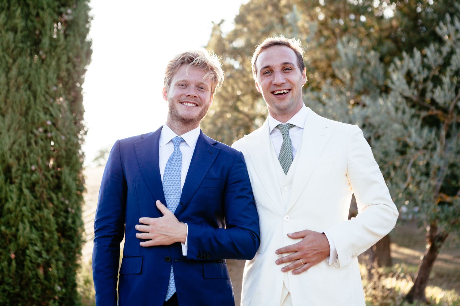 best man in a blue suite and groom in a white suite