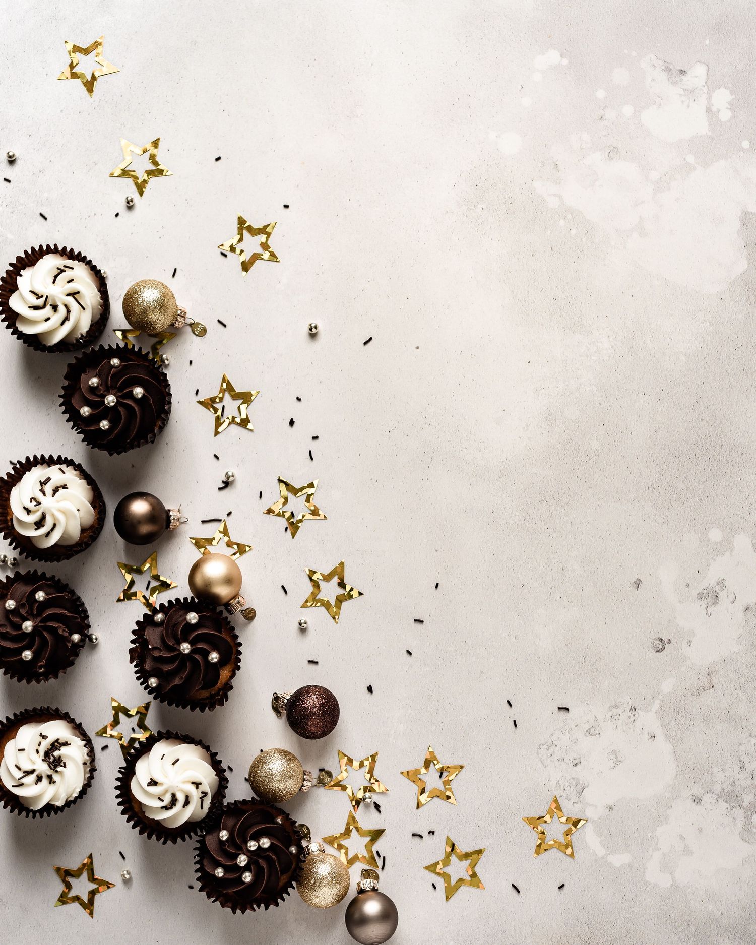 Cupcakes and foil confetti angled around a flatlay backdrop. Party, New Year, Birthday, celebrate